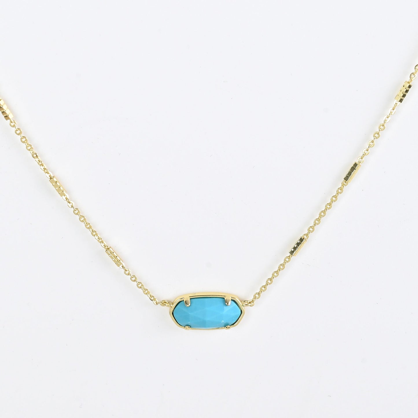 Oval crystal pendant necklace with turquoise blue stone and gold bezel on a gold chain