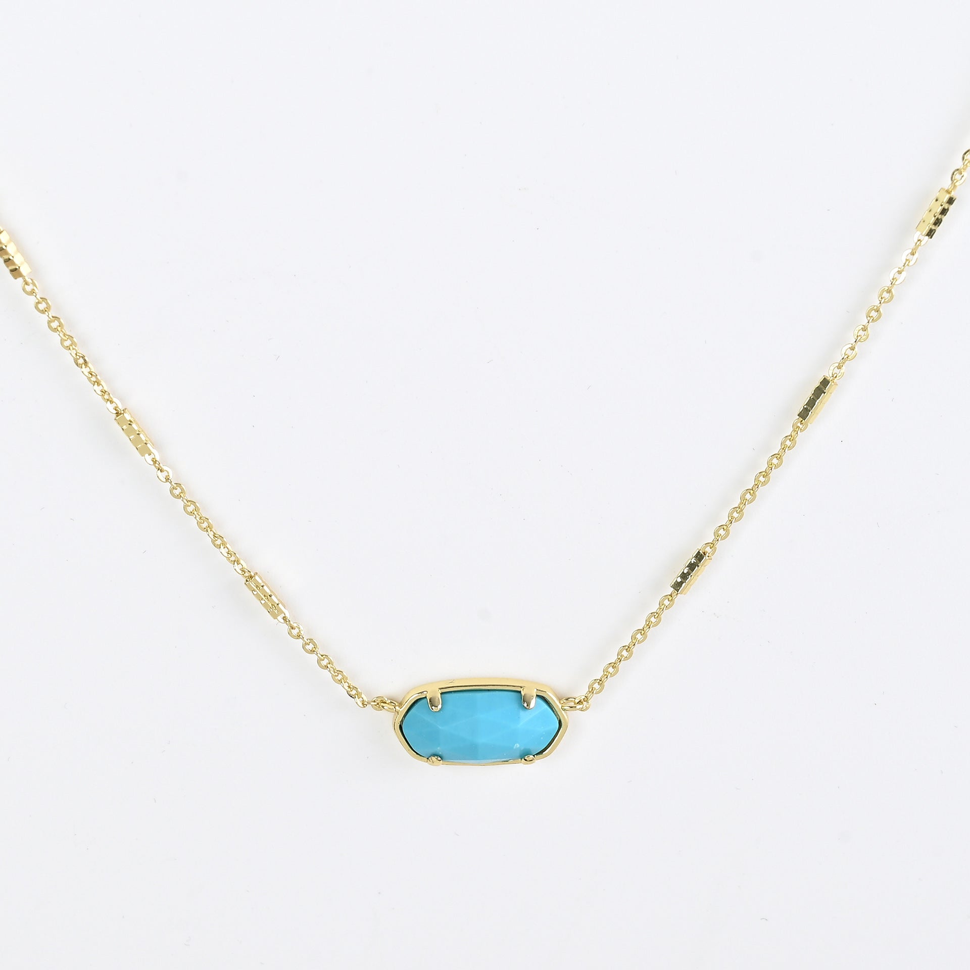 Oval crystal pendant necklace with turquoise blue stone and gold bezel on a gold chain