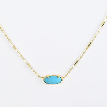 Oval crystal pendant necklace with turquoise blue stone and gold bezel on a gold chain