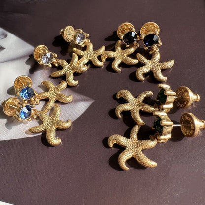 Vintage gold starfish stud earrings with dark blue round accents