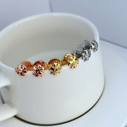 Sweet logo metal stud earrings with interlocking emblem in mixed gold and silver tones