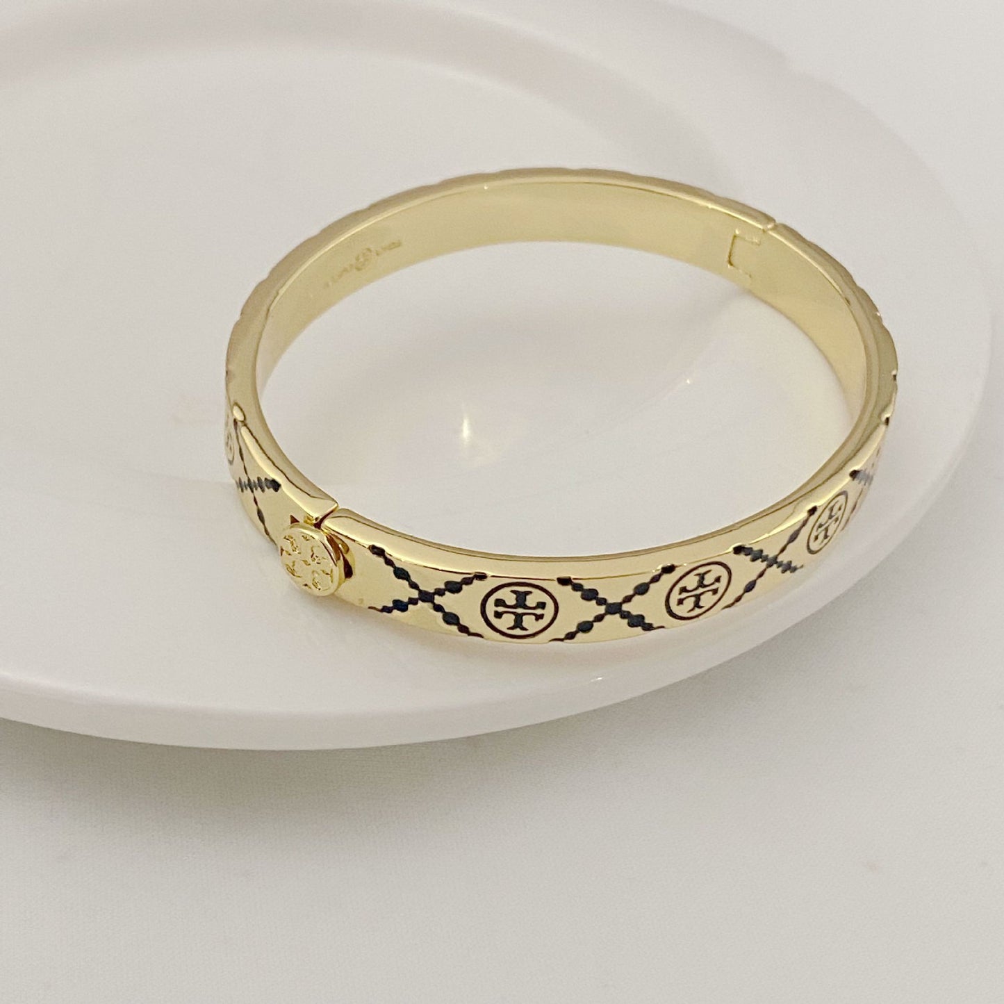 Tory Burch open metal cuff bangle, gold-tone with black enamel trim and medallions