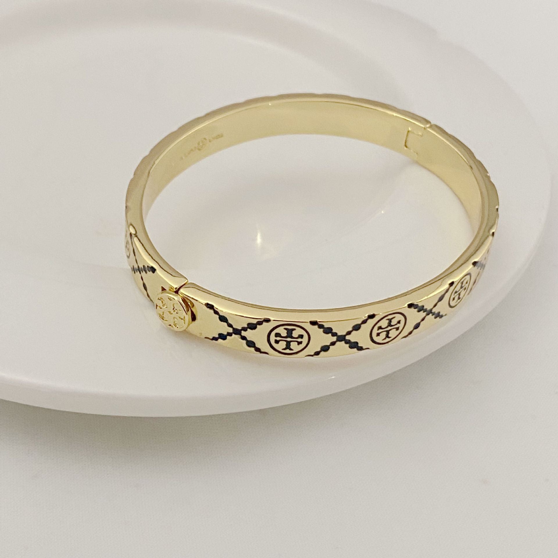 Tory Burch open metal cuff bangle, gold-tone with black enamel trim and medallions