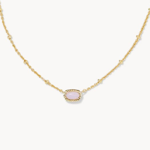 Gold-tone necklace with small oval pink gemstone pendant on a fine chain.