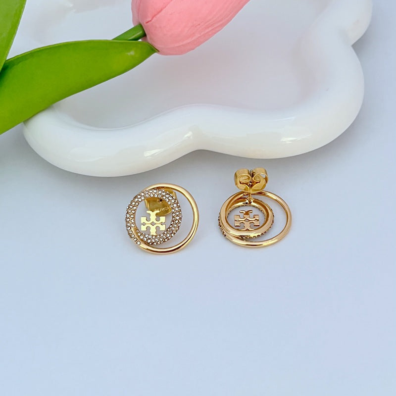 Gold-tone stud earrings with back posts and rhinestone circular logo motif