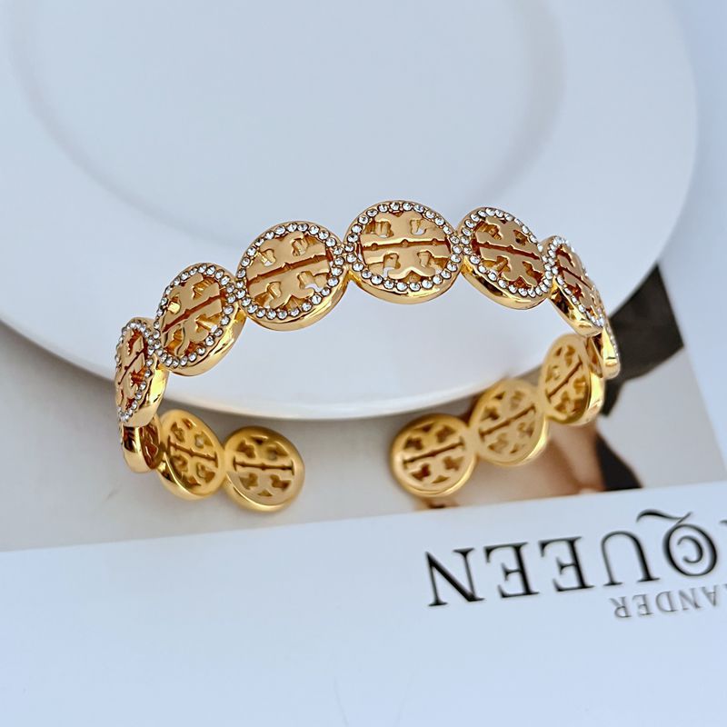 Gold-tone openwork logo bangle with diamond-studded circular links