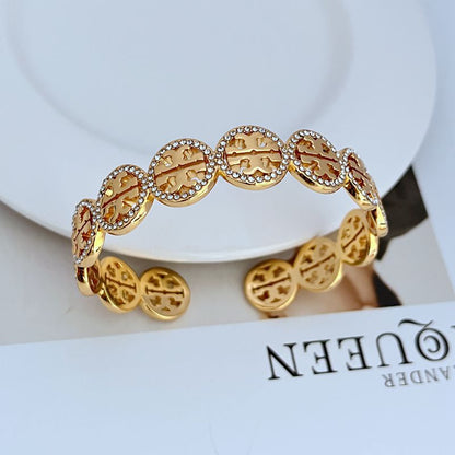 Gold-tone openwork logo bangle with diamond-studded circular links
