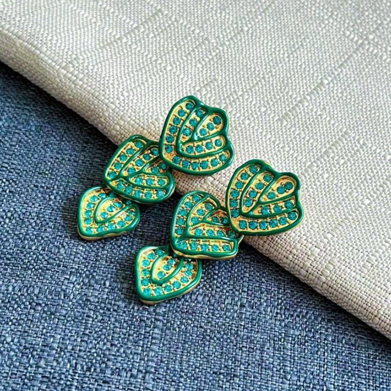 Gold-plated leaf pendant earrings with green enamel hearts and rhinestone accents