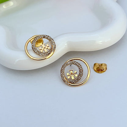Pair of gold-tone stud earrings, circular frame edged with rhinestones, logo detail