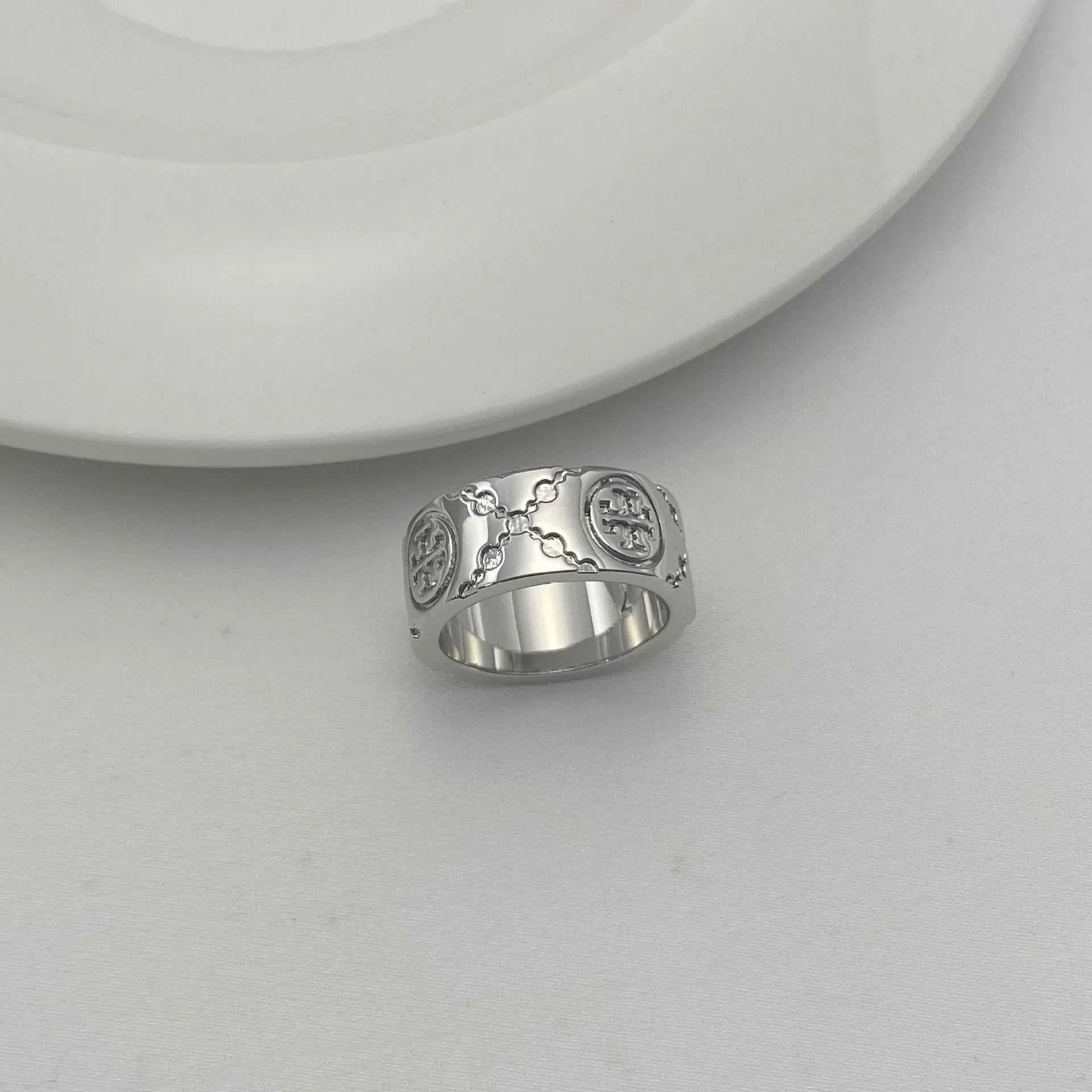 Silver-tone round logo metal ring with enamel clover pattern