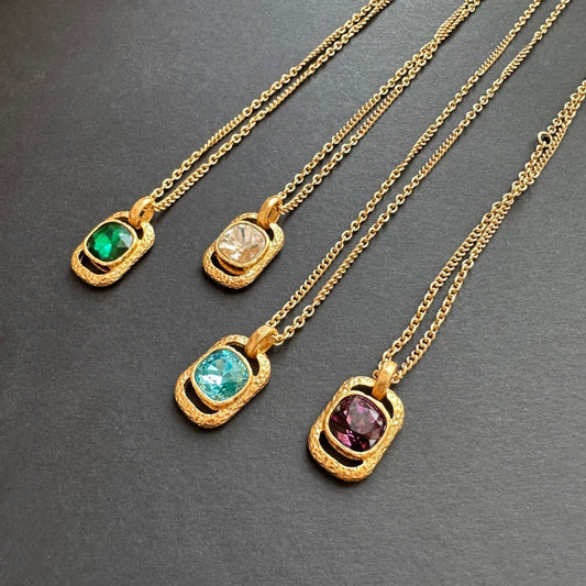 Gold-tone square pendant necklaces with faceted gemstones in teal, purple, green, and clear