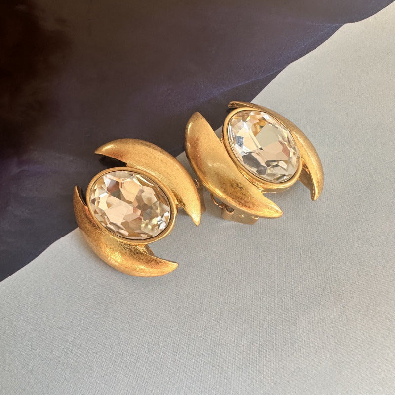 Gold-tone oval crystal stud earrings with clear faceted stones
