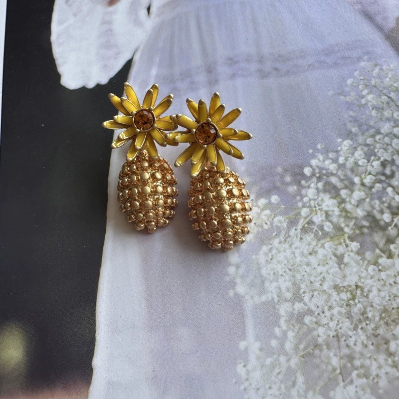 Enamel flower and pineapple diamond earrings with yellow-gold flower tops and gold textured drops.