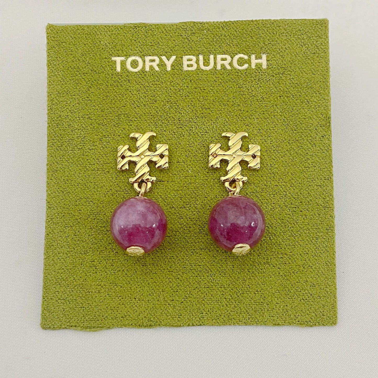 Gold-tone agate pendant earrings with round magenta stones and leaf-like top motif