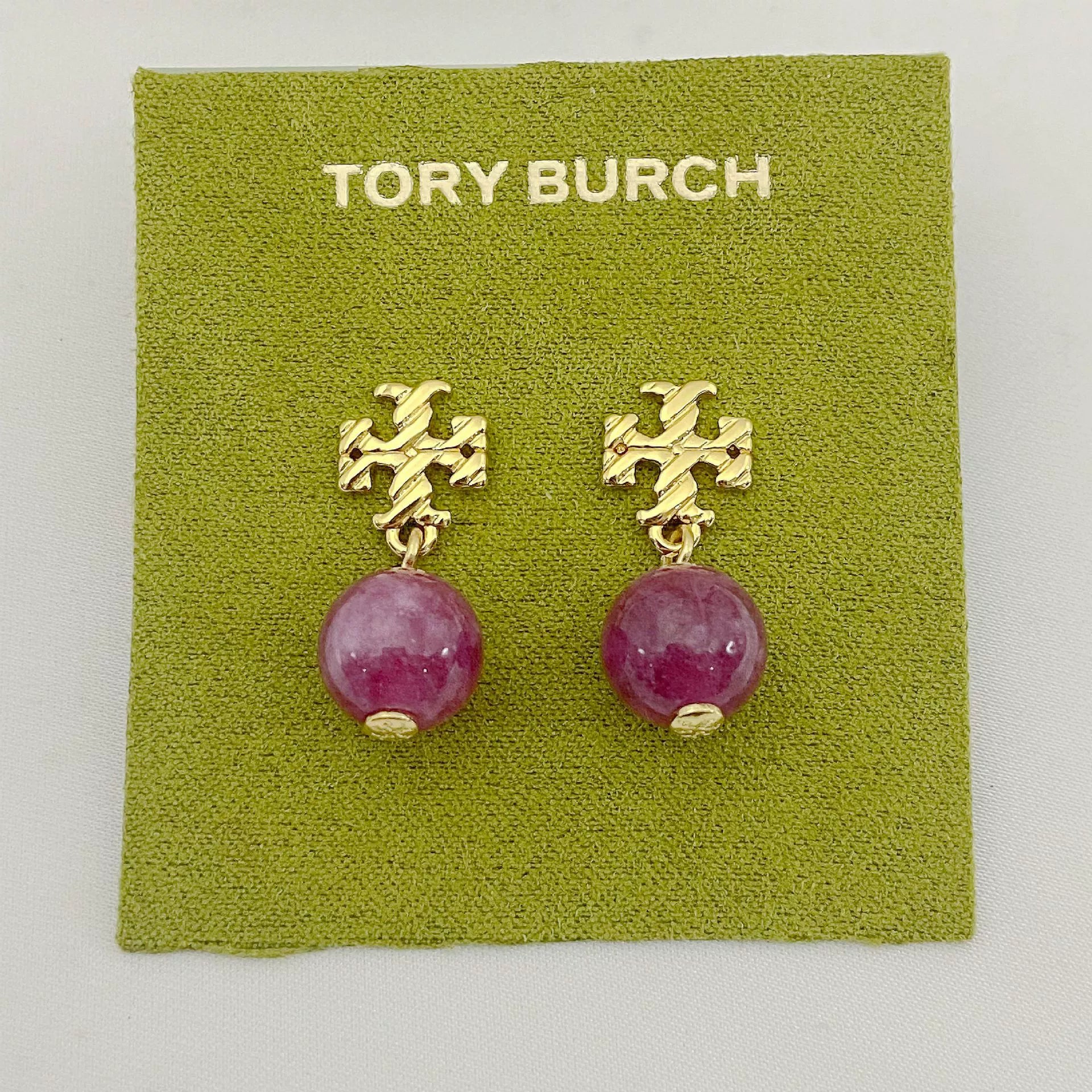 Gold-tone agate pendant earrings with round magenta stones and leaf-like top motif