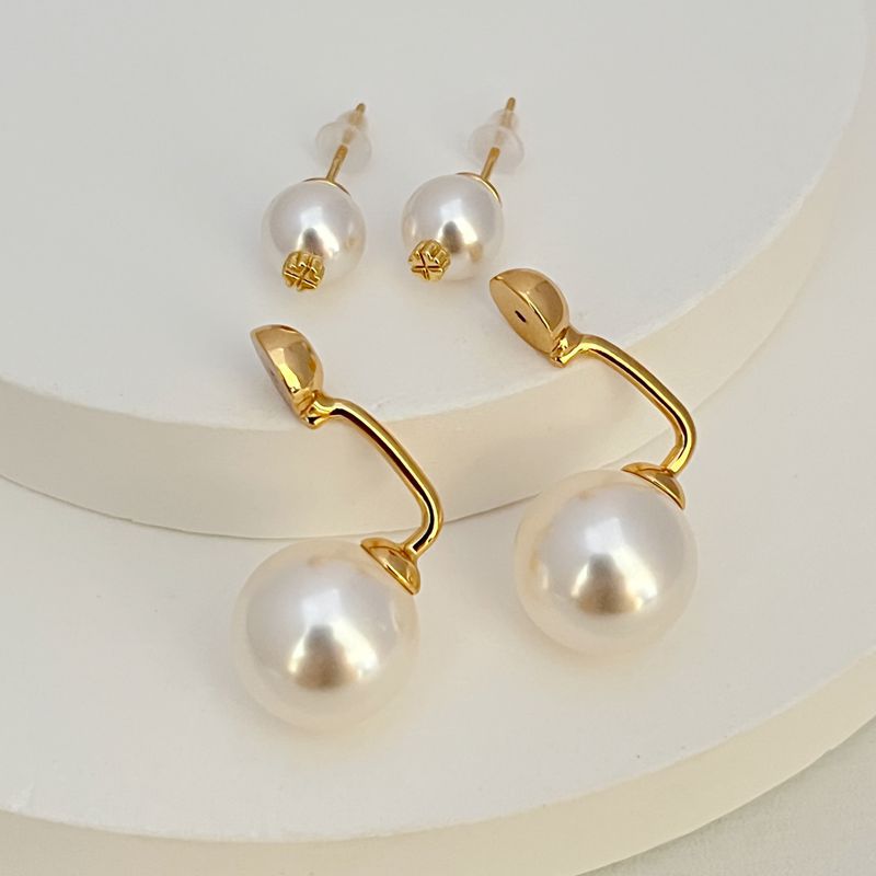 Gold-tone pearl earrings with large drop pearls and small stud pearls