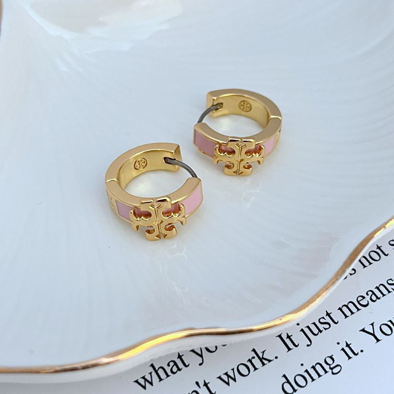 Pair of gold-tone hoop earrings with pink enamel logo and cutout detail
