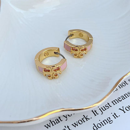 Pair of gold-tone hoop earrings with pink enamel logo and cutout detail