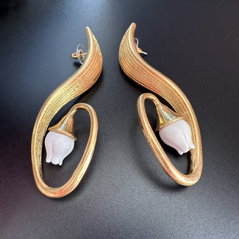 Pair of gold clip-on earrings, crescent hoops with white flower tips