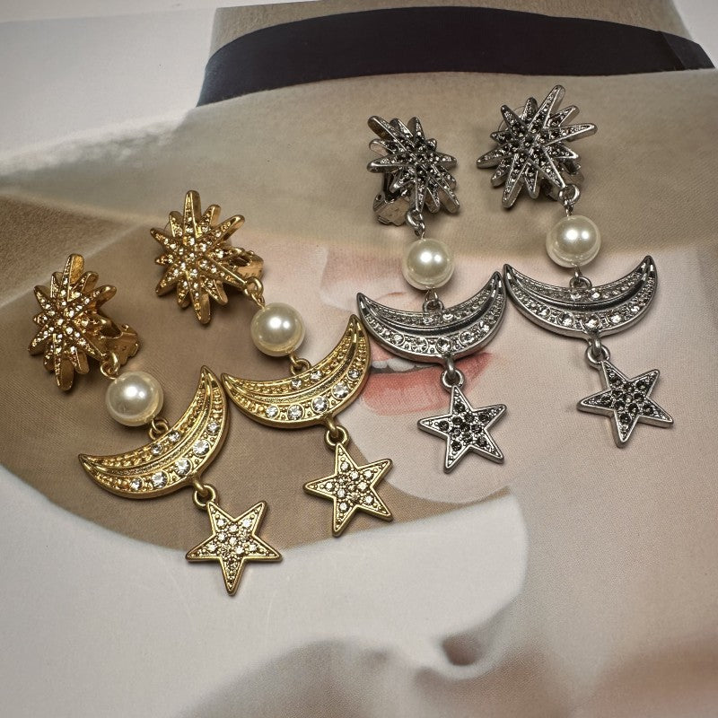 Star and moon drop earrings in mixed gold and silver tones with pearl accents