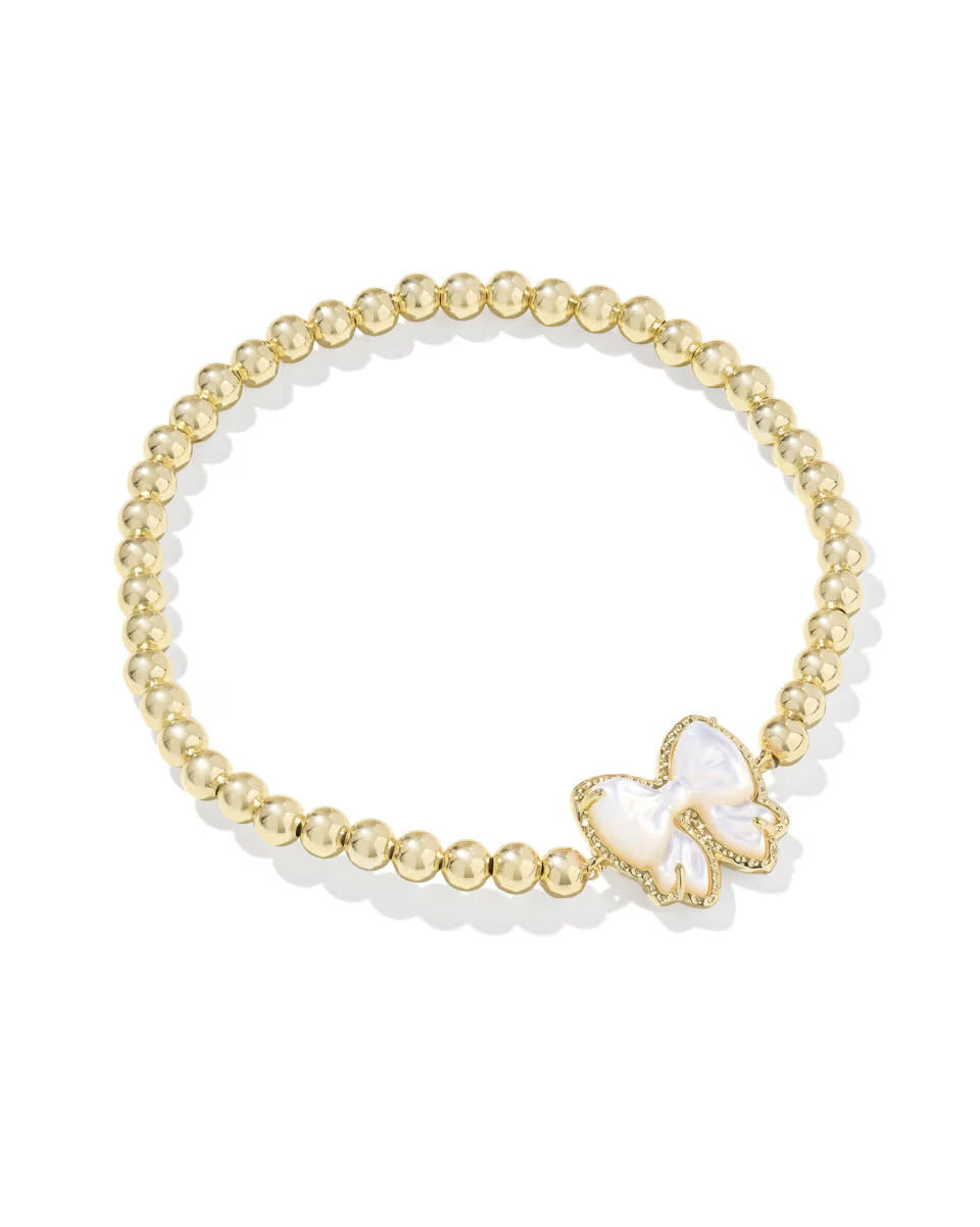 Gold-tone bead bracelet with ivory bow charm centerpiece and clear-stone edging