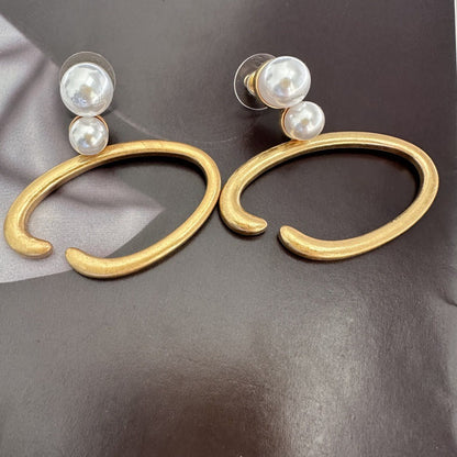 Gold-tone O-ring hoop earrings with two white pearls on each stud