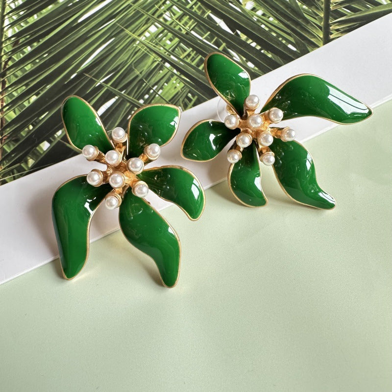 Floral enamel earrings with green enamel petals, gold trim, and pearl bead centers