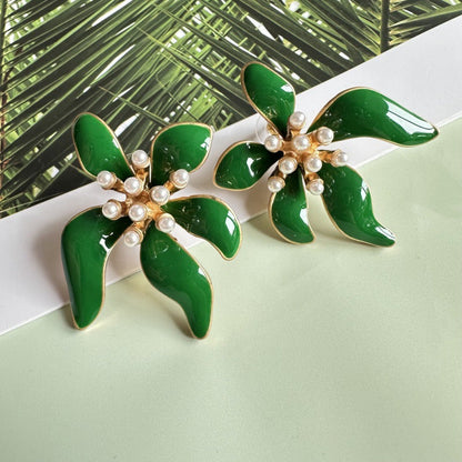 Floral enamel earrings with green enamel petals, gold trim, and pearl bead centers