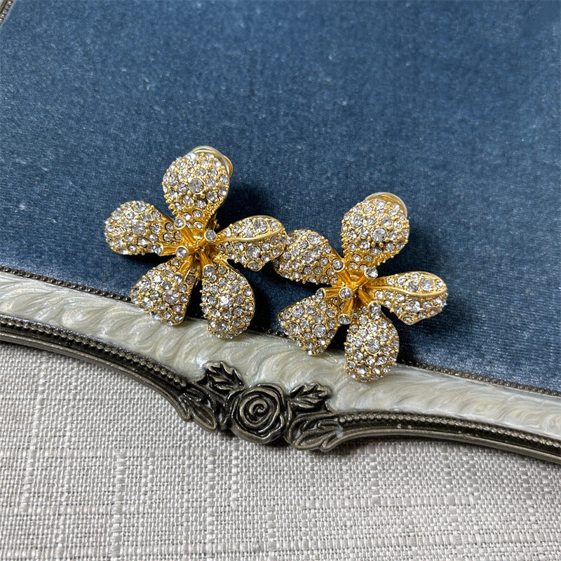 Five-petal flower stud earrings with clear crystals on gold-tone setting