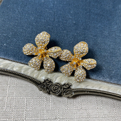 Five-petal flower stud earrings with clear crystals on gold-tone setting