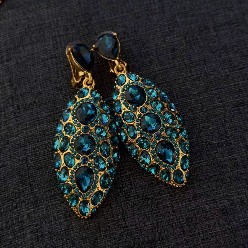 Teal blue clip-on teardrop earrings with oval faceted crystals in gold-tone settings