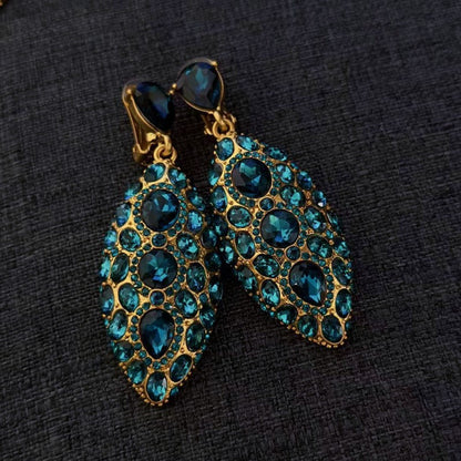 Teal blue clip-on teardrop earrings with oval faceted crystals in gold-tone settings