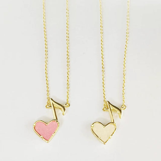 Gold-tone pendant necklaces with music note and pink or white heart charms on chain