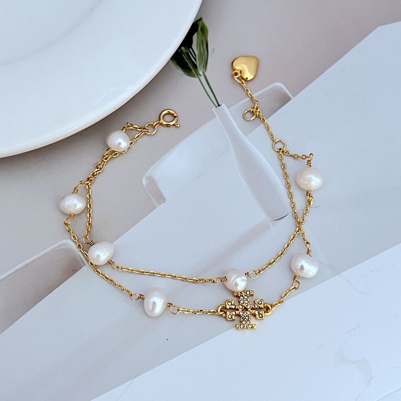 Perlenarmband, goldfarbene Kette mit weißen Perlen, Herz-Anhänger und Strassdetail