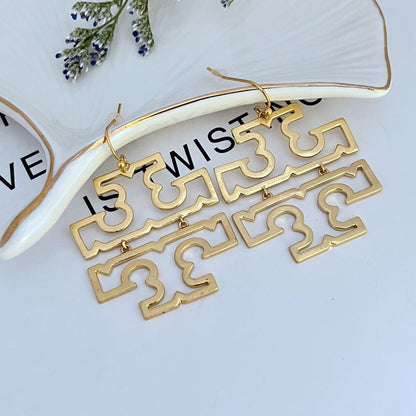 Gold openwork logo drop earrings with long geometric links and fishhook clasps.