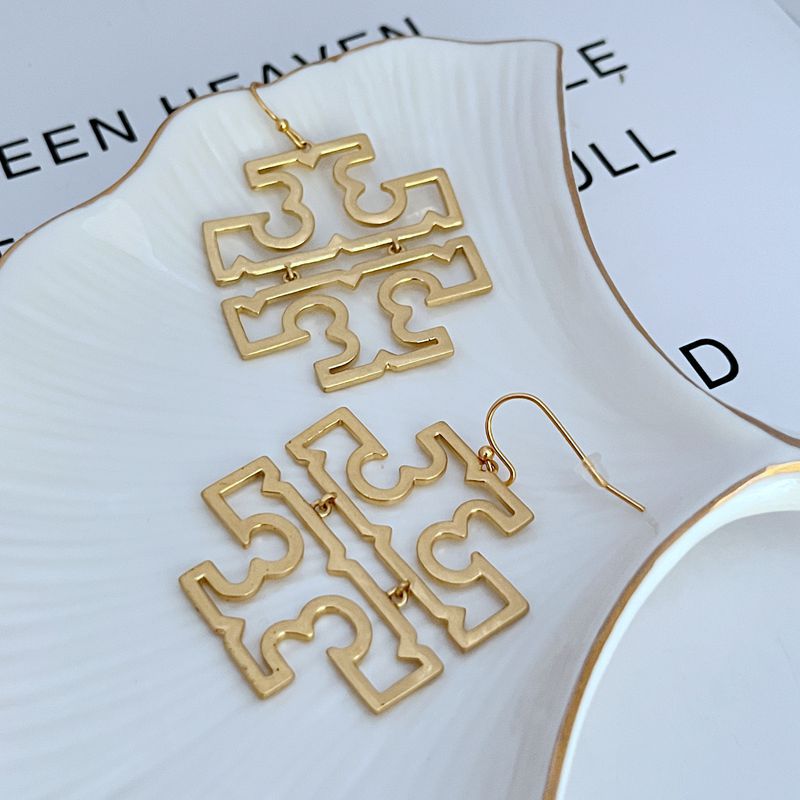 Gold openwork logo drop earrings featuring four linked geometric panels, fishhook.