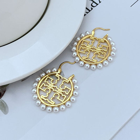 Gold round logo earrings with white pearl border and drop hooks