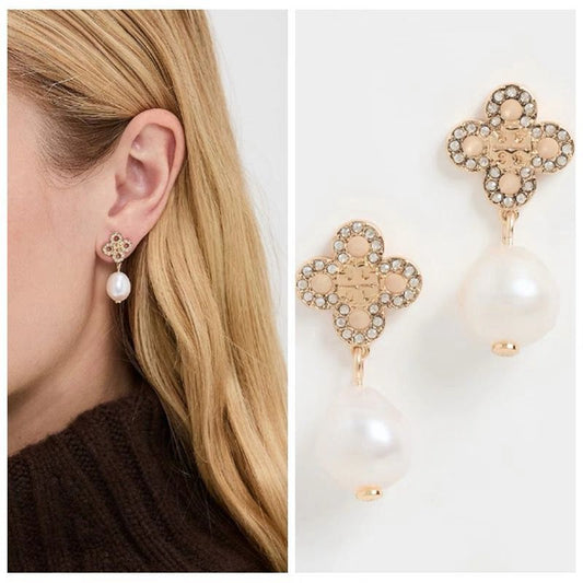 Gold four-leaf clover pearl drop earrings worn on ear, white freshwater pearl with sparkle