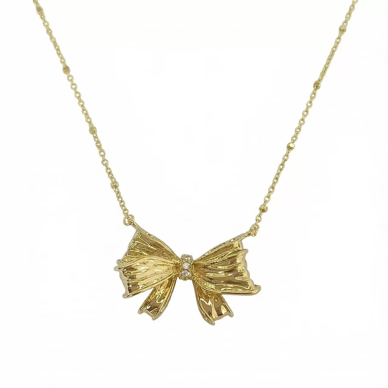 Gold bow pendant necklace with small center crystal