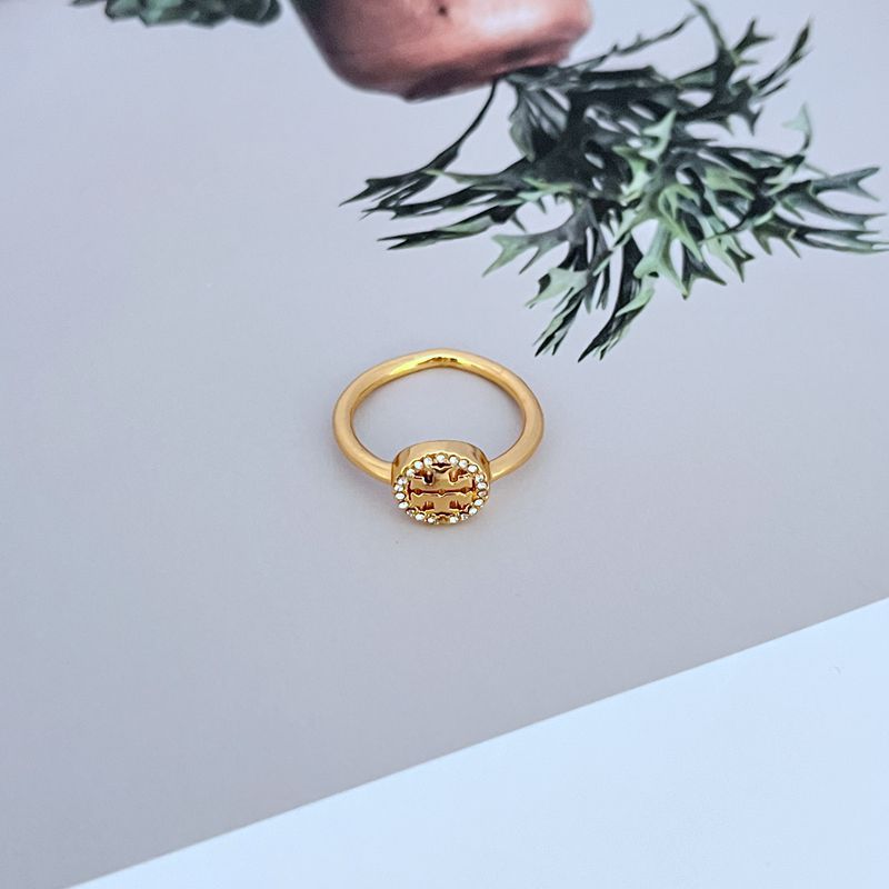 Gold-tone ring with round openwork logo and pavé stones