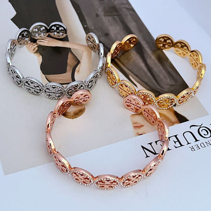 Openwork logo bangle with diamond-studded circular links in gold and rose tones
