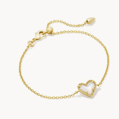 Adjustable heart charm bracelet with gold-tone chain and heart-shaped crystal pendant with pink tint.