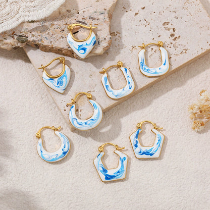 Blue marble gold-tone earrings assortment on stone, featuring hoops and drops