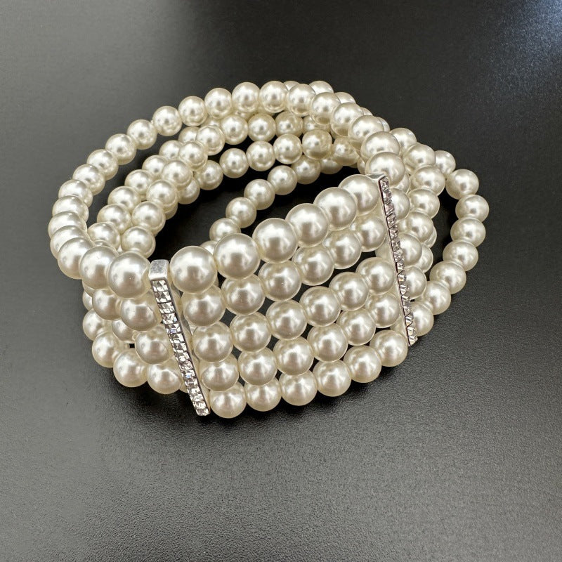 Multi-row faux pearl beaded bracelet with rhinestone bar detail, elastic stretch