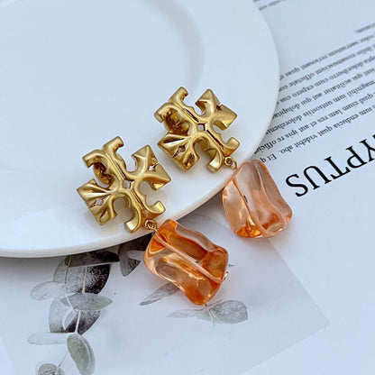 Gold-tone logo pendant earrings with orange acrylic drop charms