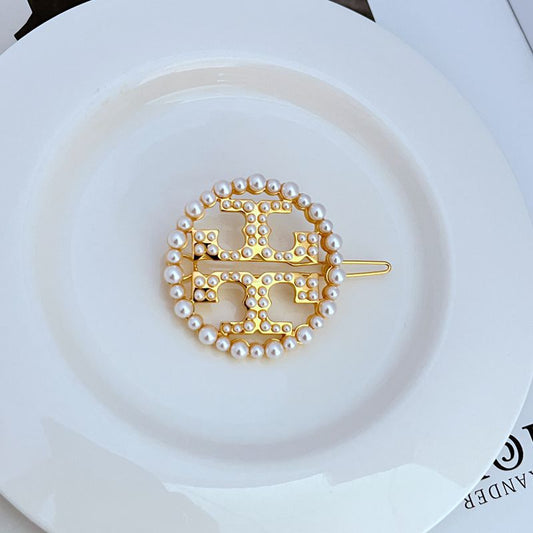 Gold hair clip, circular monogram frame with white pearls and one straight pin