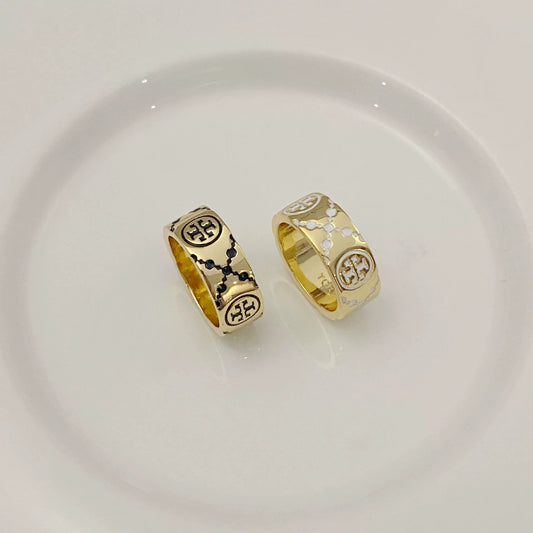 Round logo rings: one dark enamel, one white enamel, gold-tone band