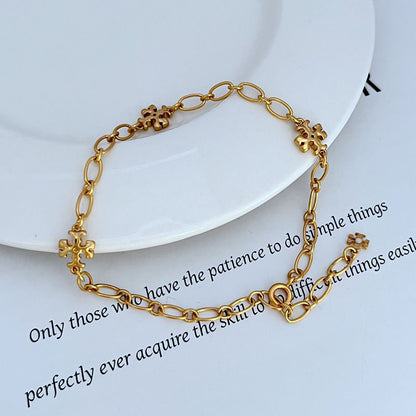 Gold-tone chain bracelet with clover logo charms and adjustable ring links