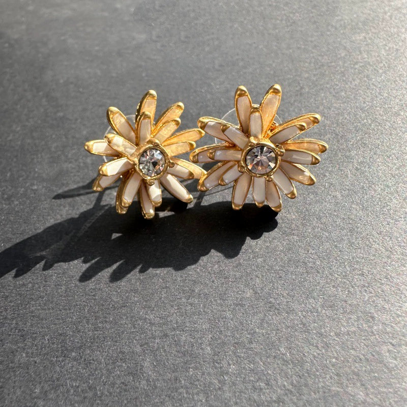 Gold enamel flower stud earrings with white petal accents and clear center stones