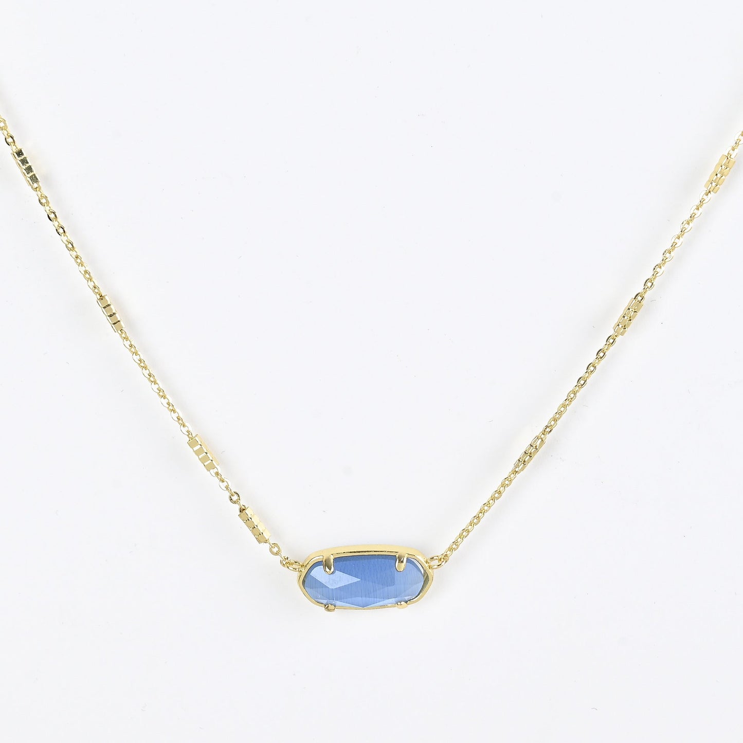 Oval crystal pendant necklace with light blue stone and gold bezel on a gold chain